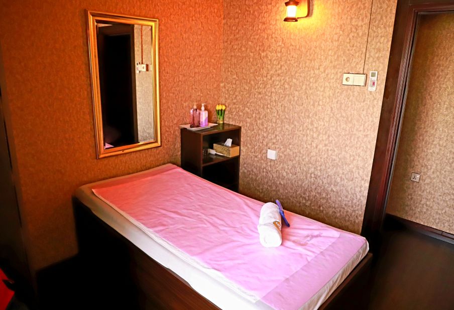 Bed with pink colored sheet in massage spa